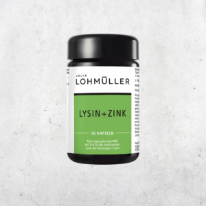 JULIA Lohmüller Lysin+Zink Kapseln im Violettglas vor einer Betonwand